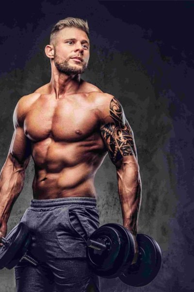 compressed_powerful-stylish-bodybuilder-with-tattoo-his-arm-doing-exercises-with-dumbbells-isolated-dark-background
